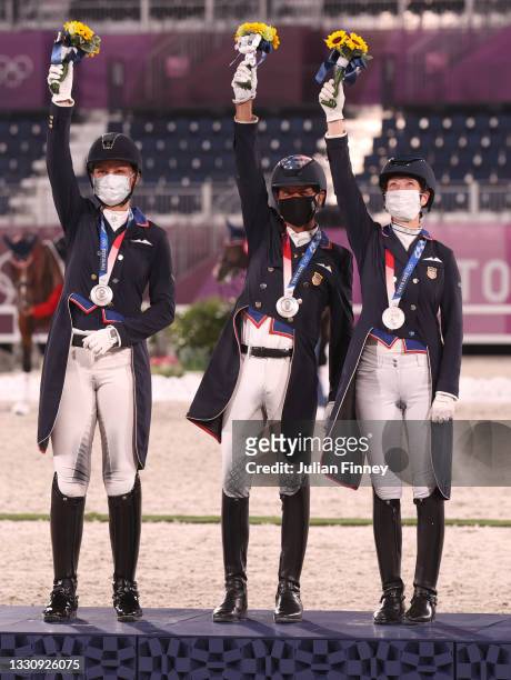 Silver medalist Adrienne Lyle, Steffen Peters, Sabine Schut-Kery of Team USA pose on the podium during the medal ceremony in the Dressage Team Grand...