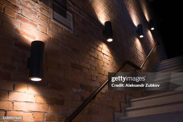 classic stylish sconces or lamps on the wall, on the background of a brick wall. selective focus. working lamps turned on at dusk or at night, outdoors. copy the place for the text. - lamp bildbanksfoton och bilder