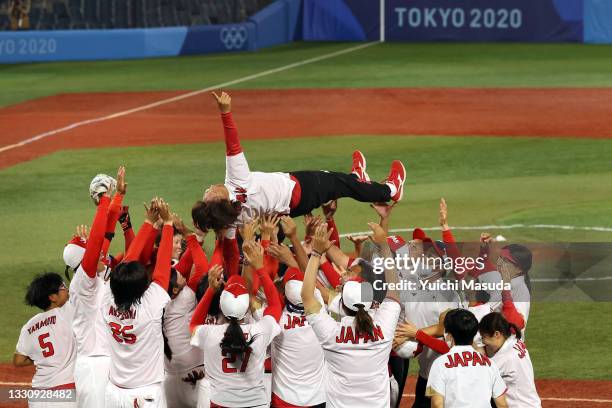 Manager Reika Utsugi of Team Japan is thrown in the air by her team after defeating Team United States 2-0 in the Softball Gold Medal Game between...