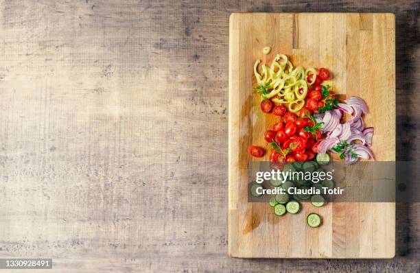 chopped vegetables (tomatoes, cucumber, spanish onion, and yellow bell pepper) on wooden cutting board - köksbänk bildbanksfoton och bilder