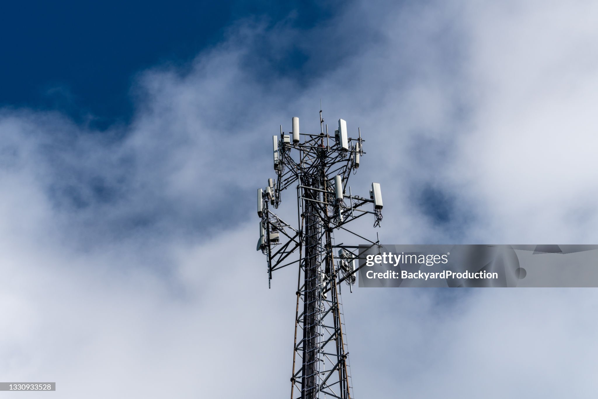 Stock photo of cell phone or wireless aerial tower surrounded by clouds