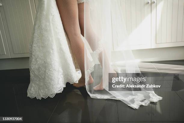 a woman or girl in a light fluttering evening dress or negligee, stood on her toes. perfect beautiful slender bare feet. morning gathering of the bride, preparation for the ceremony. - wedding feet stock-fotos und bilder