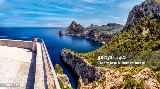 panoramic view of woman contemplating the sea from a lookout point (es colomer) on the coast of formentor, majorca island. - 監視塔 ストックフォトと画像