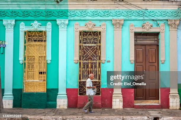 senior  man walking down a street in trinidad, cuba - sancti spiritus provincie stockfoto's en -beelden