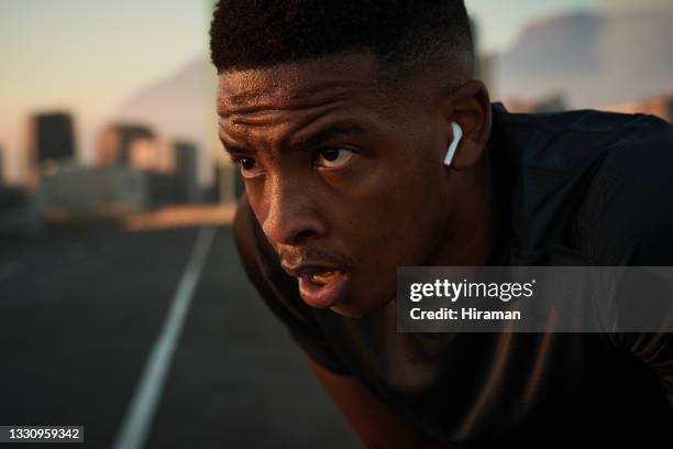 shot of a handsome young man taking a moment to catch his breath after a morning run in the city - sports pictures of the month 2014 stockfoto's en -beelden