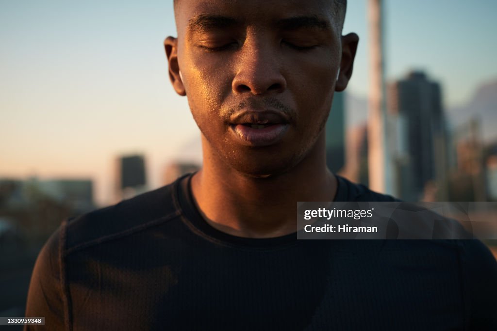 Shot of a handsome young man taking a moment to catch his breath after a morning run in the city