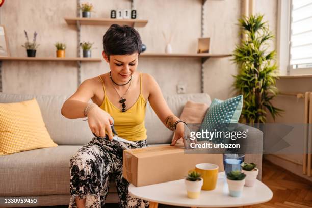 woman customer opening cardboard box parcel - online shopping opening package stockfoto's en -beelden