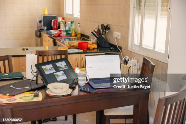 still life of a home office setup on the dining table - cable mess stockfoto's en -beelden