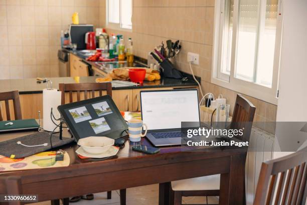 still life of a home office setup on the dining table - messy kitchen stock pictures, royalty-free photos & images