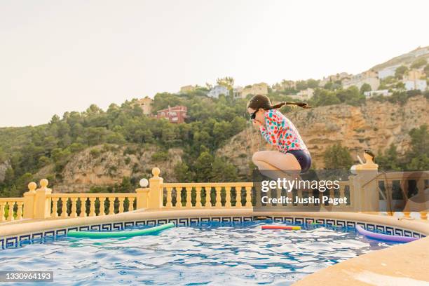 young girl jumping into the swimming pool - jump in pool stock pictures, royalty-free photos & images