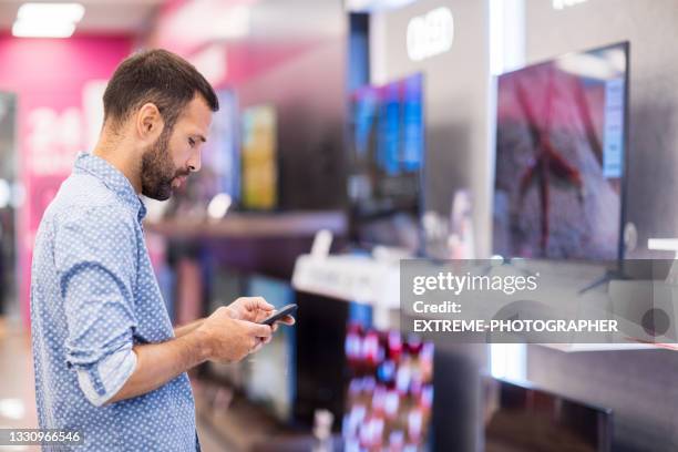 verificando informações durante as compras de homens - loja de produtos eletrônicos - fotografias e filmes do acervo