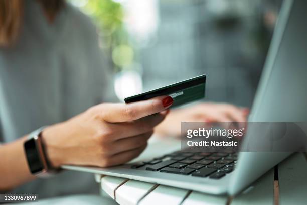 junge frau mit kreditkarte und laptop - credit card stock-fotos und bilder