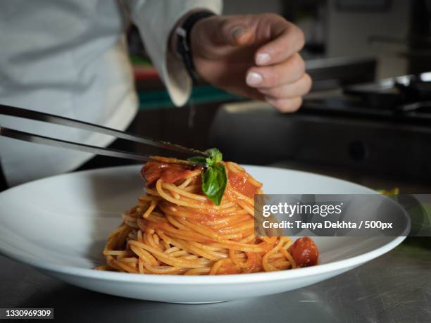 midsection of man having spaghetti in restaurant,milan,italy - milan food stock pictures, royalty-free photos & images