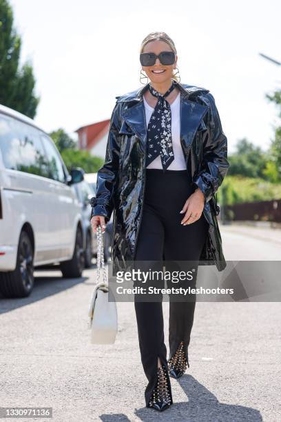 Host Alessandra Geissel wearing a black stretch vinyl shiny wetlook trench coat by Saint Laurent, a white ripped tank top by Zara, black high waist...