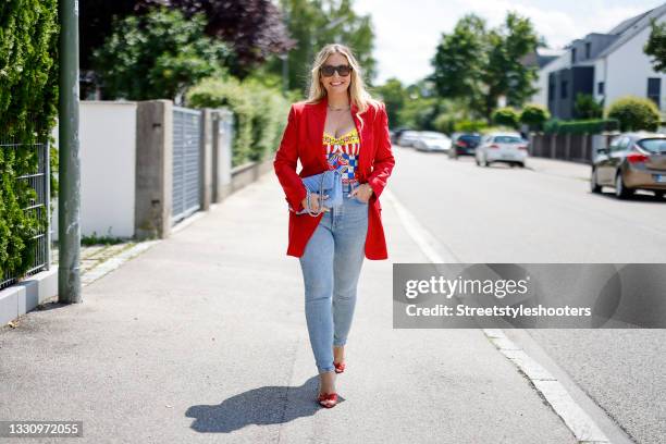 Host Alessandra Geissel wearing a red blazer by Dolce & Gabbana, light blue skinny denim jeans pants by Zara, a multicolored Carretto-print charmeuse...