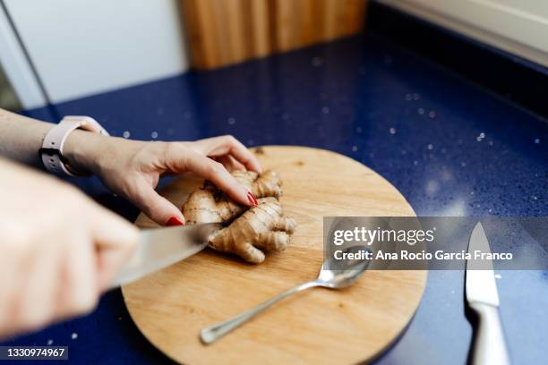 cutting fresh ginger root - ginger root stock pictures, royalty-free photos & images