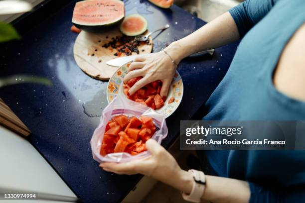 filling a plastic bag with watermelon slices to freeze - food bag stock pictures, royalty-free photos & images