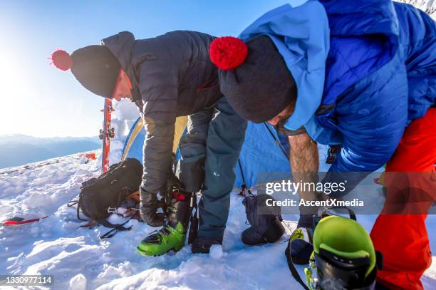 backcountry skiers prepare for a day in the canadian rockies - skischoen stockfoto's en -beelden