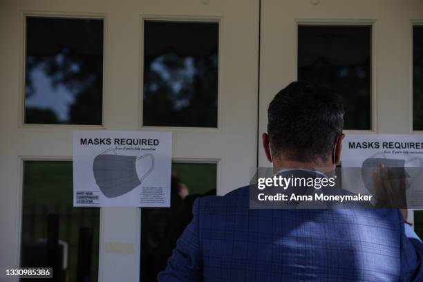 Fin Gomez, a journalist with CBS News and White House Correspondents Association board member, replaces signs for mask-wearing guidance around the...