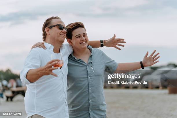 family meeting on the beach - uncle nephew stock pictures, royalty-free photos & images