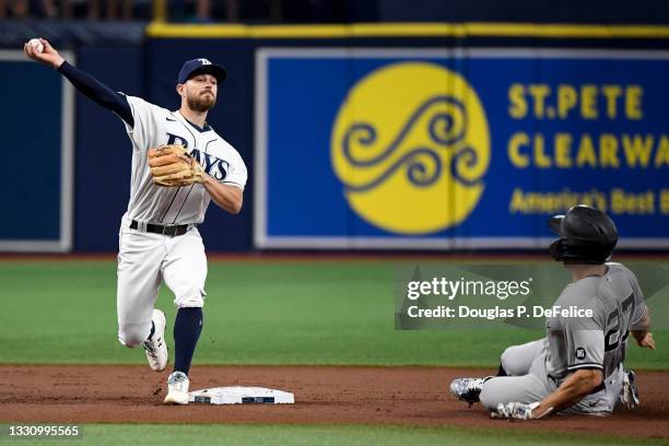 Brandon Lowe of the Tampa Bay Rays turns a double play over Giancarlo Stanton of the New York Yankees at second base in the first inning at Tropicana...