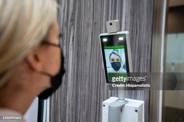 woman getting her temperature checked before entering the mall - biosecurity stock pictures, royalty-free photos & images