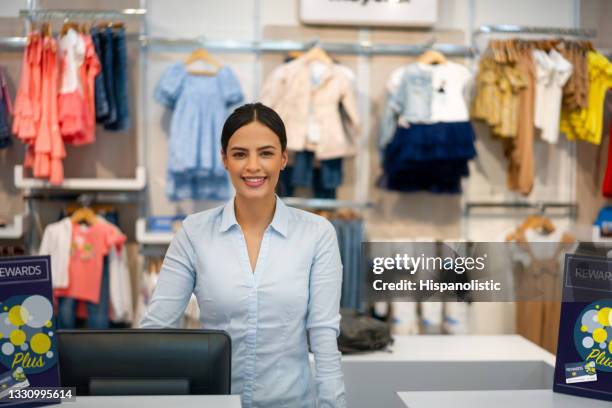 glückliche kassiererin, die in einem kinderbekleidungsgeschäft arbeitet - shop till stock-fotos und bilder