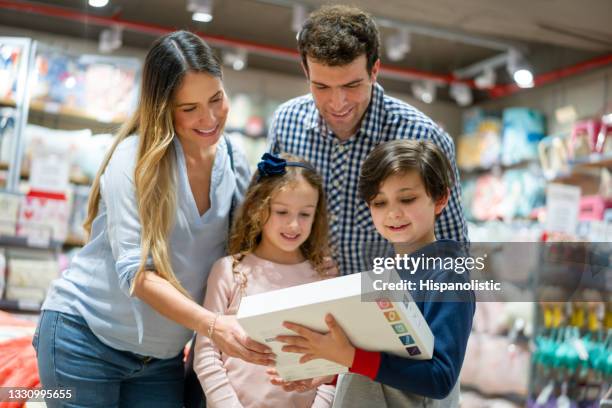 happy family shopping and buying toys for the kids at a department store - brinquedo imagens e fotografias de stock