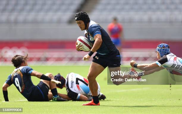 Masakatsu Hikosaka of Team Japan makes a break past Yong Heung Chang of Team South Korea to score a try during the Rugby Sevens Men's Placing 11-12...