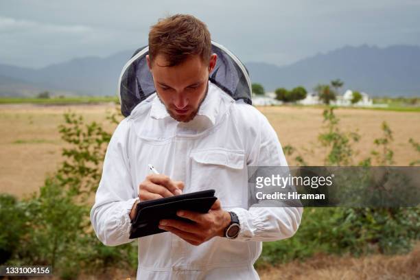 shot of a beekeeper using a digital tablet while working on a farm - apiculture stock pictures, royalty-free photos & images