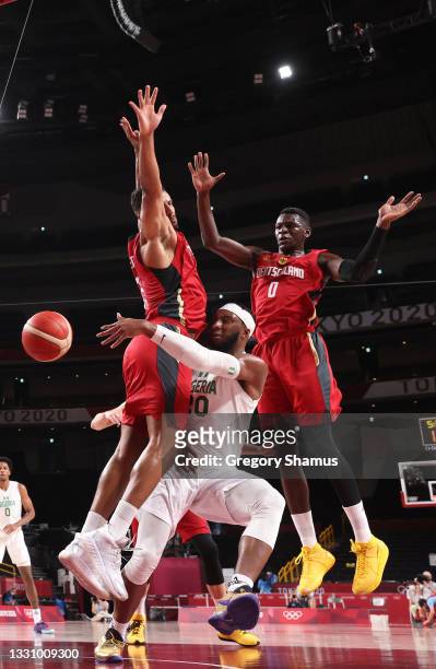 Josh Okogie of Team Nigeria passes under pressure from Johannes Thiemann and Isaac Bonga of Team Germany during the first half of a Men's Preliminary...