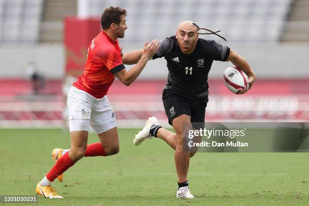 Joe Webber of Team New Zealand fends off the tackle from Ollie Lindsay-Hague of Team Great Britain during the Rugby Sevens Men's Semi-final match...
