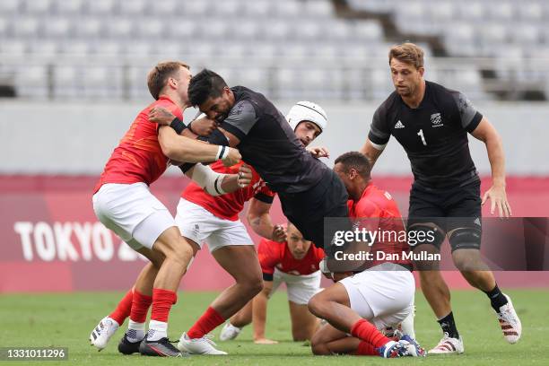 Dylan Collier of Team New Zealand is tackled by Dan Norton and Harry Glover of Team Great Britain during the Rugby Sevens Men's Semi-final match...