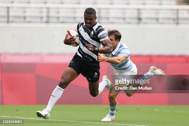 Jiuta Wainiqolo of Team Fiji runs in to score a try under pressure from Felipe del Mestre of Team Argentina during the Rugby Sevens Men's Semi-final...
