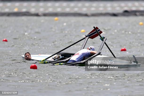 Kristoffer Brun and Are Weierholt Strandli of Team Norway hold on to their capsized boat during the Lightweight Men's Double Sculls Semifinal A/B 1...