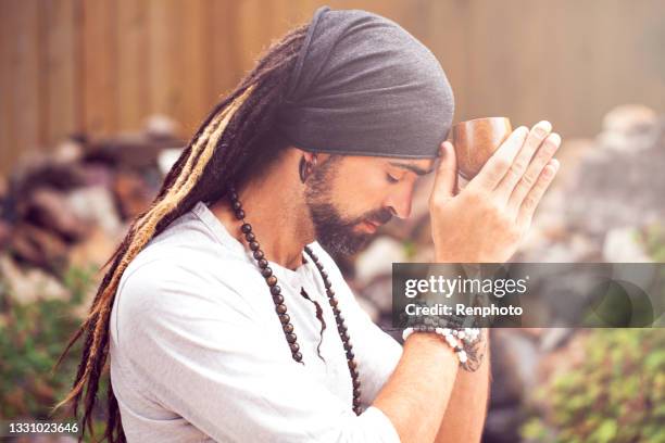 man holding ceremonial drink to his third eye - ceremonie stockfoto's en -beelden