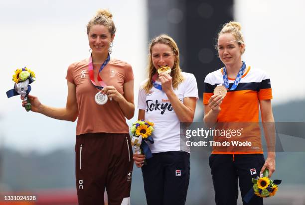Silver medalist Marlen Reusser of Team Switzerland, Annemiek van Vleuten of Team Netherlands kisses her gold medal, and bronze medalist Anna van der...