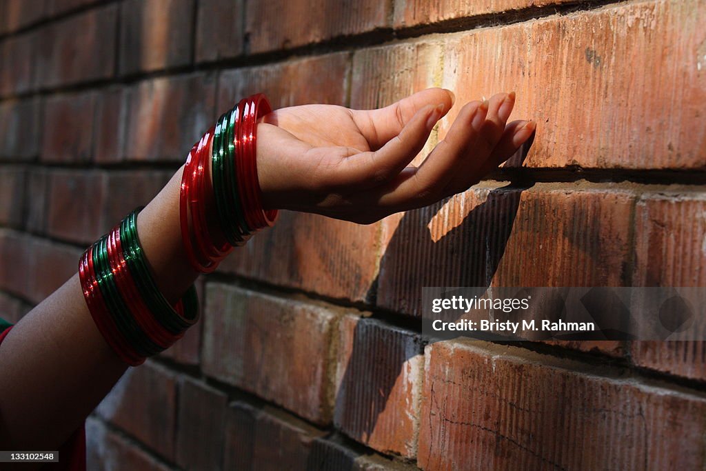 Woman hand against brick wall