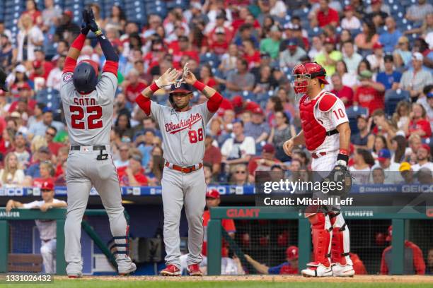 Juan Soto of the Washington Nationals celebrates with Gerardo Parra in front of J.T. Realmuto of the Philadelphia Phillies after hitting a three run...