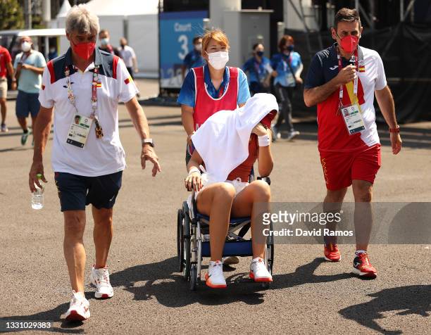 Paula Badosa of Team Spain is helped away from the court in a wheelchair after having to retire from her Women's Singles Quarterfinal match against...