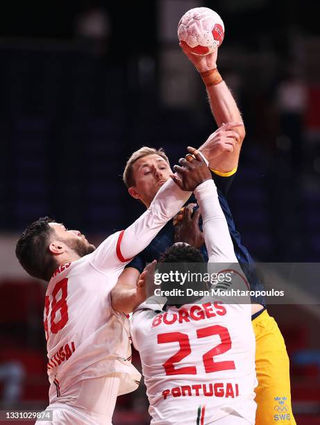 Albin Lagergren of Team Sweden is challenged by Fabio Magalhaes and Alexis Borges of Team Portugal during the Men's Preliminary Round Group B...