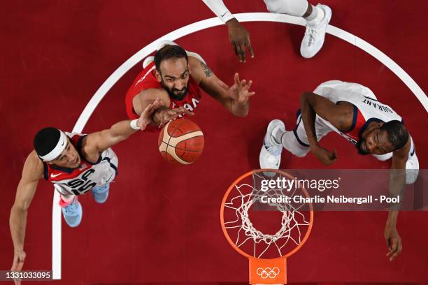 Hamed Haddadi of Team Iran goes up for a shot against Devin Booker and Kevin Durant of Team United States during a Men's Preliminary Round Group A...