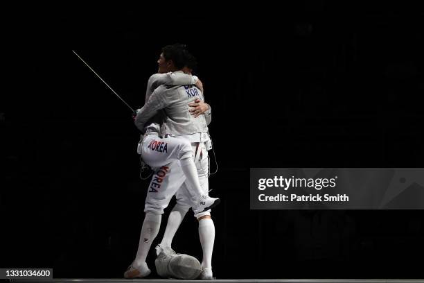 Sanguk Oh of Team South Korea hugs Bongil Gu of Team South Korea after defeating Team Germany in Men's Sabre Team Semifinal on day five of the Tokyo...