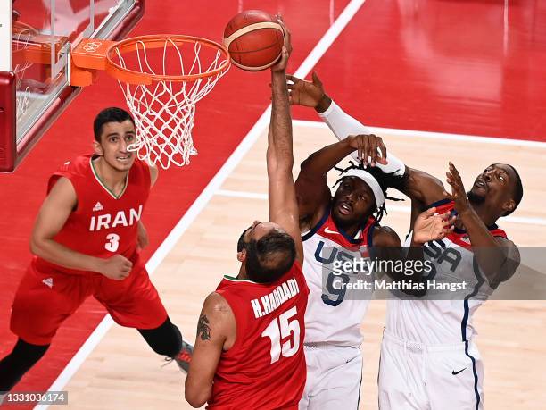 Hamed Haddadi of Team Iran shoots over Jerami Grant and Khris Middleton of Team United States as teammate Mohammadsina Vahedi looks on during the...