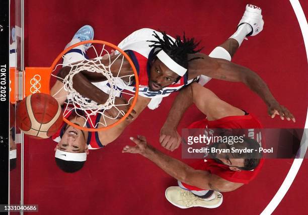 Devin Booker and teammate Jerami Grant of Team United States fight for Hamed Haddadi of Team Iran for possession of a rebound during the first half...