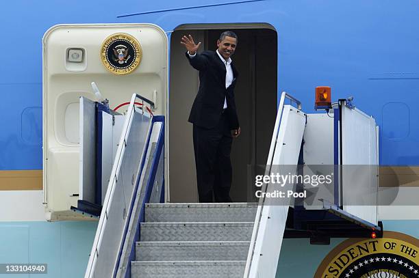 President Barack Obama waves from the top of the stairs as he boards Air Force One to depart from RAAF Darwin during the second day of his 2-day...