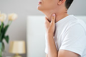 Sore throat, men with pain in neck in home interior