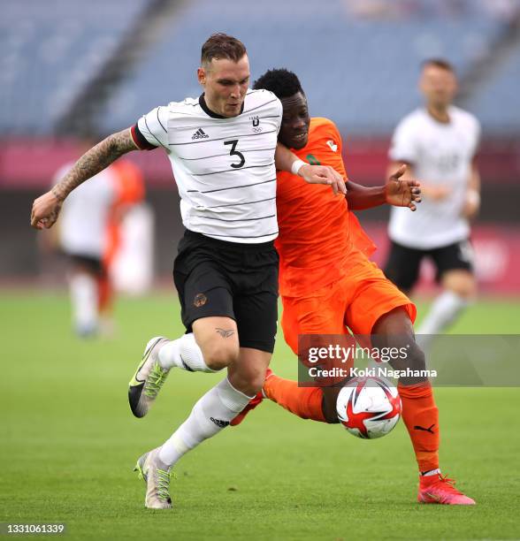 David Raum of Team Germany battles for possession with Youssouf Dao of Team Ivory Coast during the Men's Group D match between Germany and Cote...