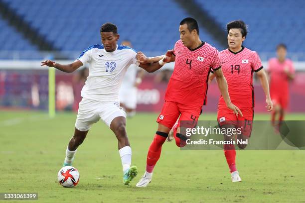 Douglas Martinez of Team Honduras is challenged by Minjae Kim and Yoonseong Kang of Team South Korea during the Men's Group B match between Republic...