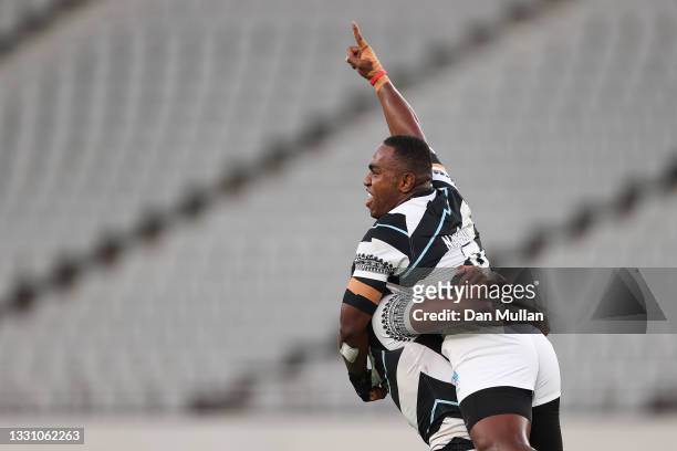 Waisea Nacuqu of Team Fiji is lifted by Kalione Nasoko during the Rugby Sevens Men's Gold Medal match between New Zealand and Fiji on day five of the...